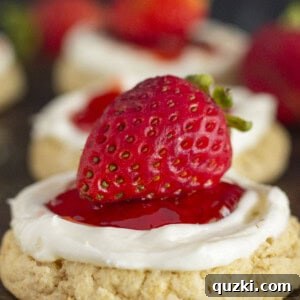 Strawberry Cheesecake Cookies on a baking sheet, topped with fresh strawberries.