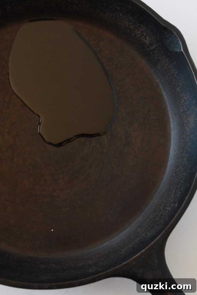 Unlock the Full Potential of Your Cast Iron 4 Applying a tablespoon of vegetable oil to the bottom of a clean cast iron skillet for seasoning.