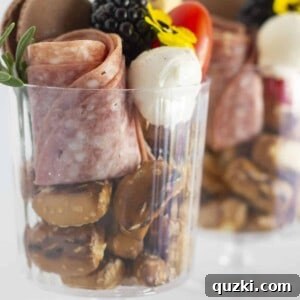 Two mini charcuterie cups in clear plastic cups, perfectly assembled.