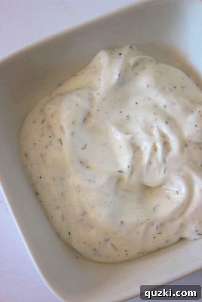 Ingredients for the creamy dill dressing, including sour cream, mayonnaise, dill, and black pepper.