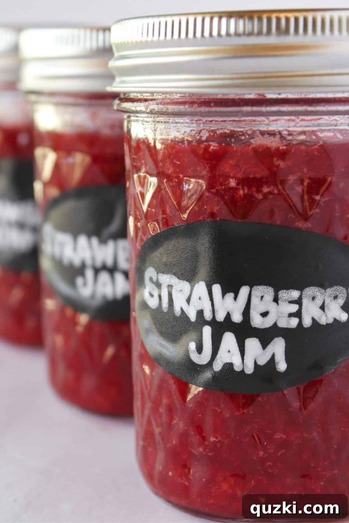 Simple Pectin-Free Homemade Strawberry Jam 7 Three jars of strawberry jam without pectin in jars with lids and labels.