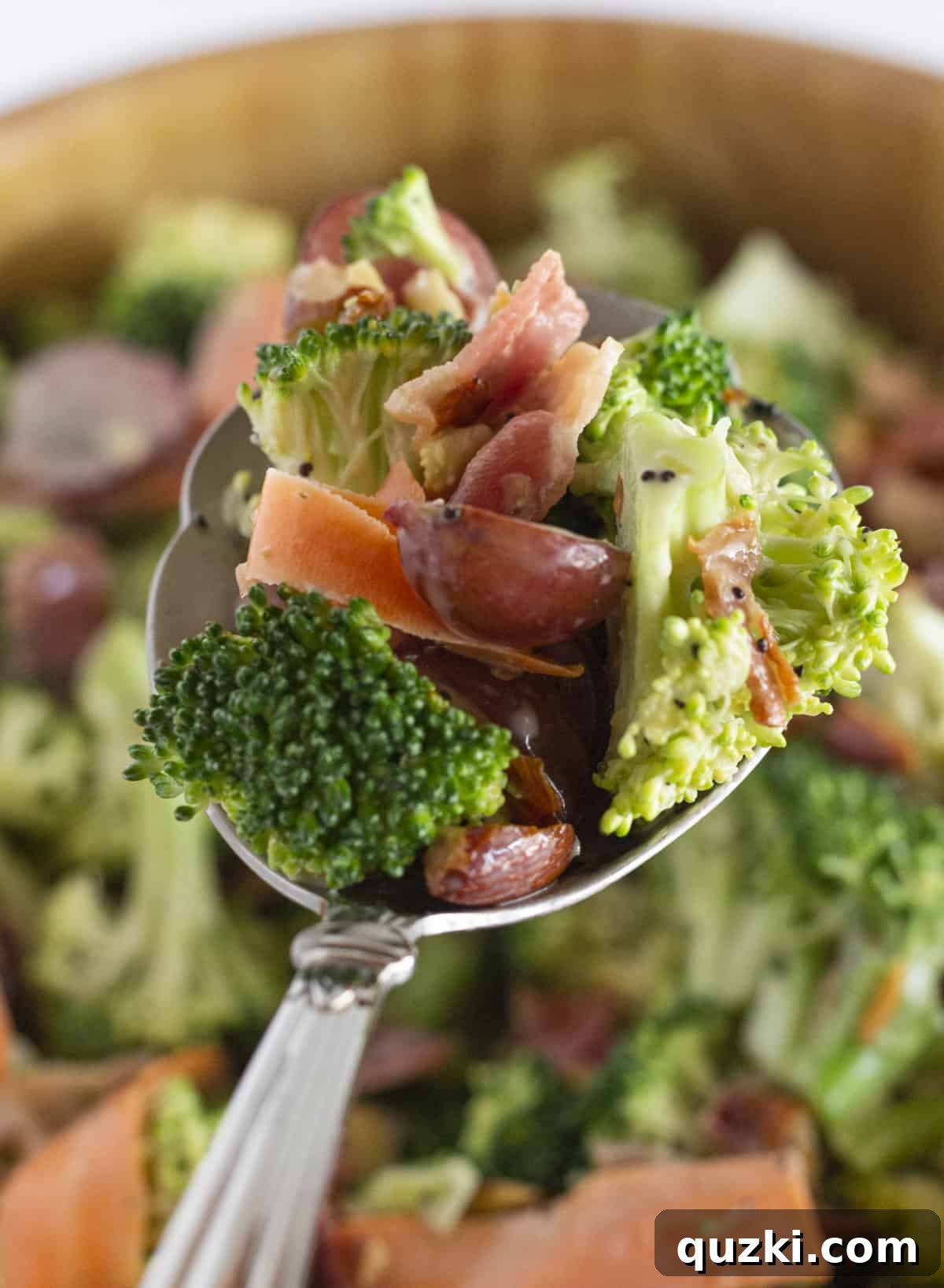 Smoky Bacon Broccoli Crunch Salad 6 A large serving spoon scooping a portion of the delicious Broccoli Crunch Salad from a bowl, highlighting its crunchy texture.