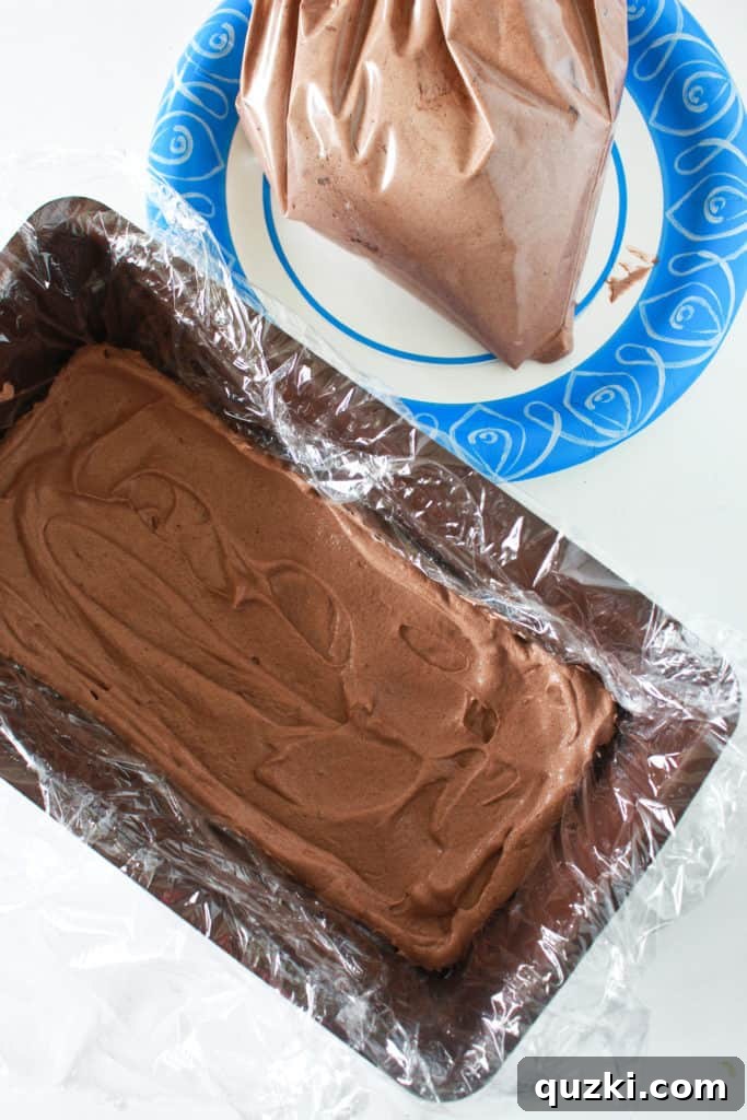 Piping the very first smooth layer of creamy chocolate pudding into a plastic-wrap-lined loaf pan, setting the foundation for a delicious Twix Icebox Cake.