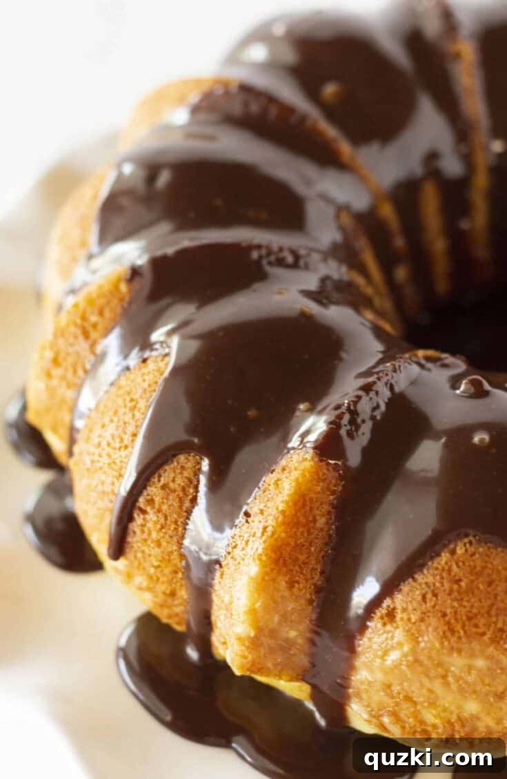 Easy Boston Cream Pie Poke Cake, a bundt cake filled with cream and topped with chocolate.