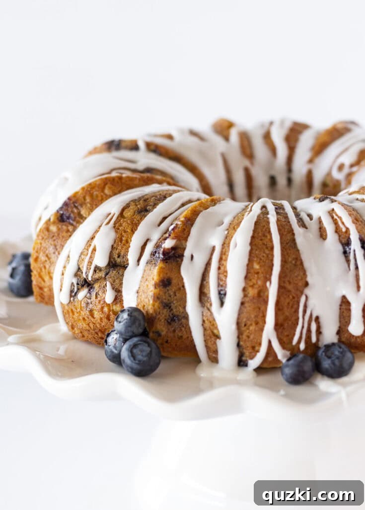 Moist Blueberry Bundt Cake topped with a sweet glaze, bursting with fresh blueberries.