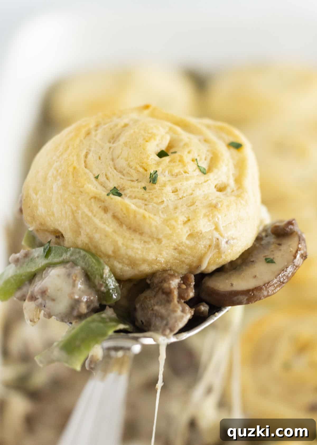 Ultimate Philly Cheesesteak Bake 8 A spoonful of cheesesteak casserole with a cheese pull.