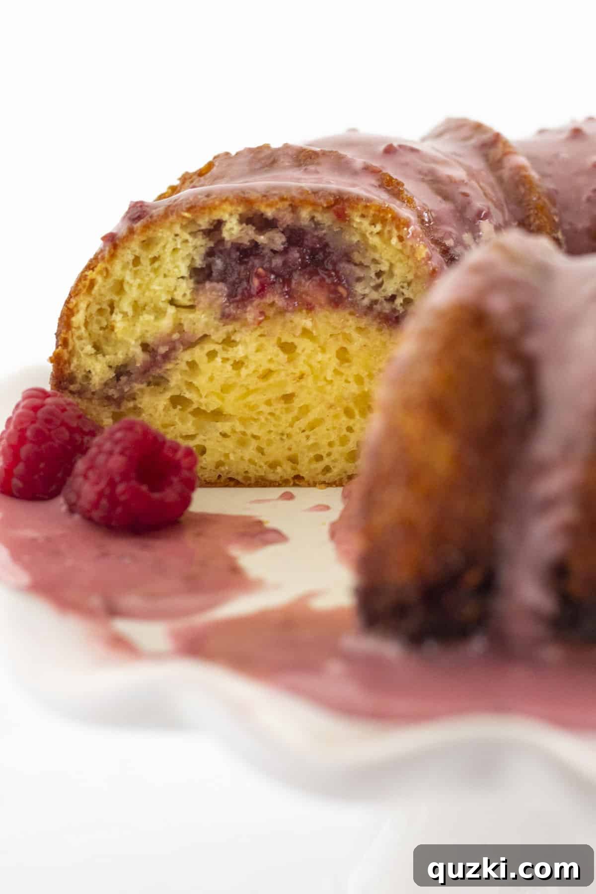Sunny Raspberry Lemon Bundt Cake 7 A close-up view of a slice of Raspberry Lemonade Bundt Cake, showcasing the delicate texture and the beautiful raspberry filling swirl.