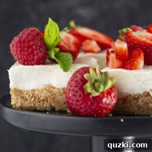 No Bake Cheesecake Bars on a black plate with fresh strawberries.