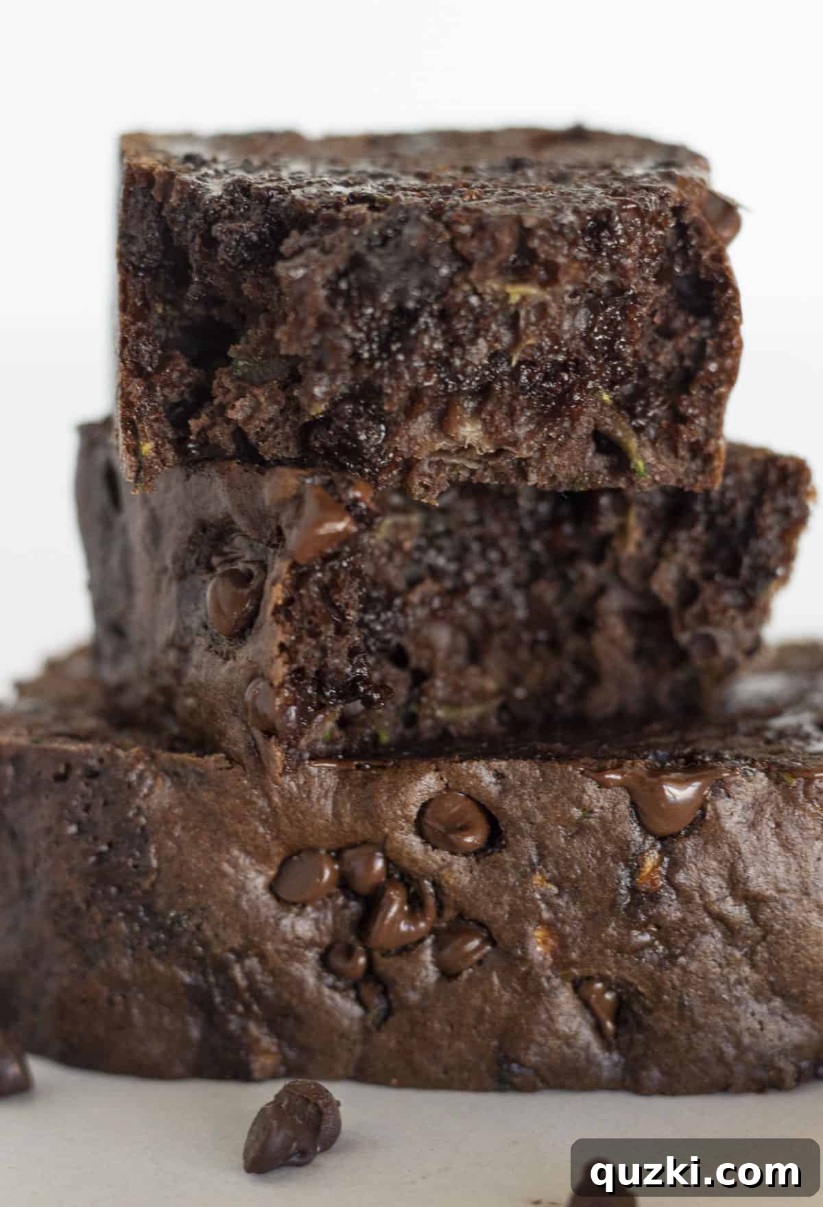 No-Fail Double Chocolate Zucchini Bread Cake Mix 2 Two pieces of double chocolate zucchini bread stacked on each other, showcasing its moist texture and chocolate chips.