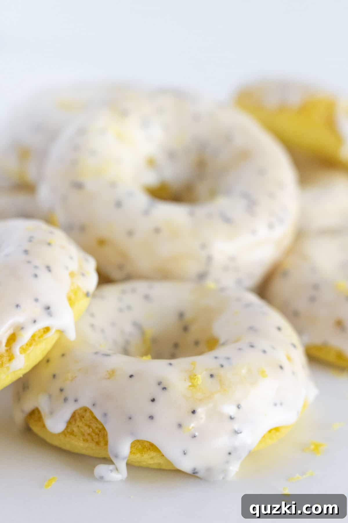 Oven-Baked Lemon Donuts with Zesty Poppy Seed Glaze 2 Stacked lemon donuts with glistening poppy seed glaze, beautifully arranged and ready to be enjoyed.