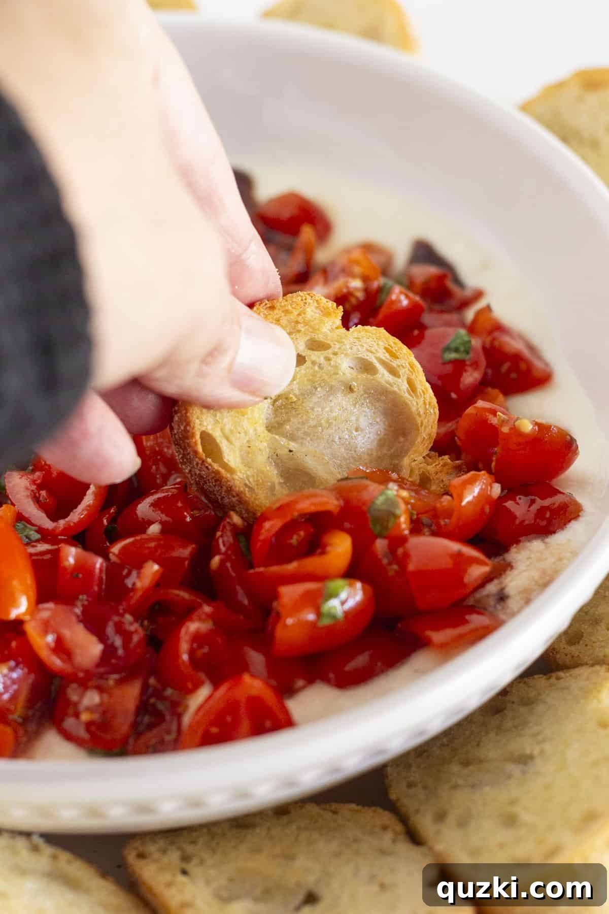 Creamy Ricotta Bruschetta Dip 7 Using a bread crisp to scoop bruschetta dip.