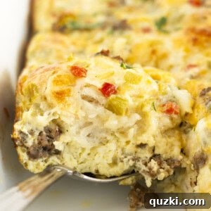 Serving a square of biscuit casserole with sausage and eggs.
