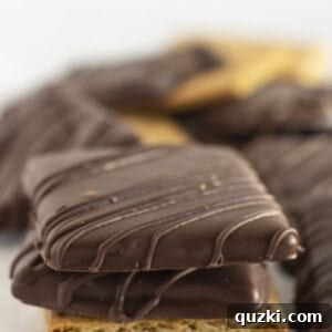 Stacked chocolate covered graham crackers on a plate, ready to be served.