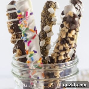 Chocolate covered pretzel rods with toppings, in a mason jar.