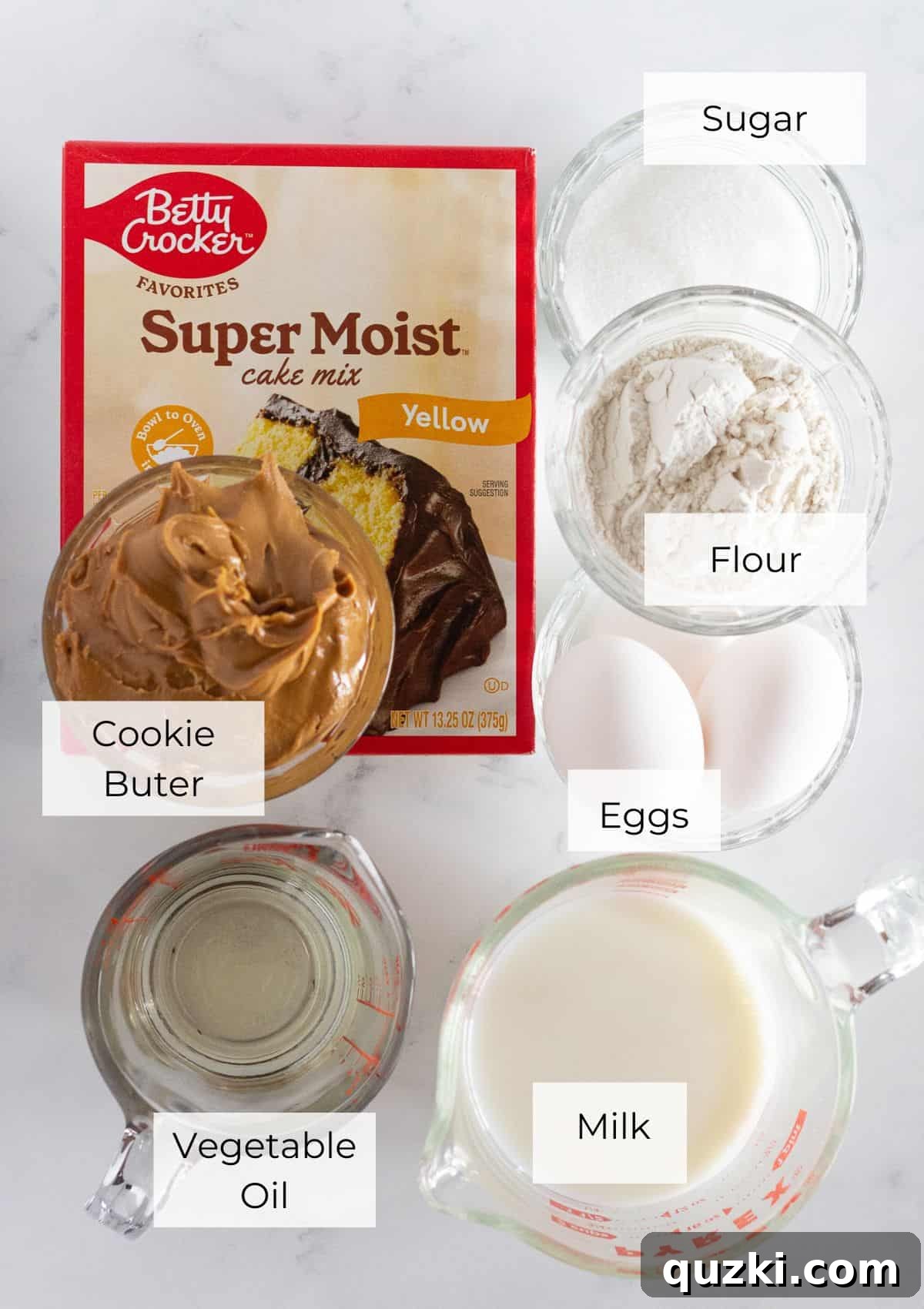 A colorful array of ingredients laid out on a clean surface, ready for making Biscoff Cookie Butter Cupcakes.