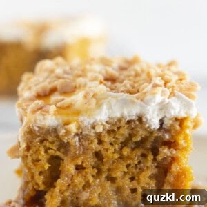 Two pieces of pumpkin poke cake on white plates.