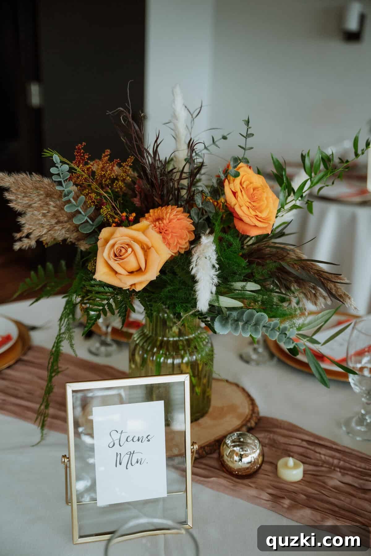 Close-up view of a wedding reception table name, displayed in a gold frame, showcasing a personalized location instead of a traditional number, adding a unique touch.