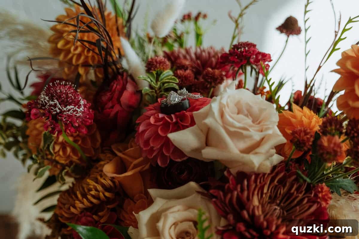 A close-up shot of the bridal bouquet, beautifully arranged with vibrant flowers, showcasing the couple's wedding rings nestled within its blooms.
