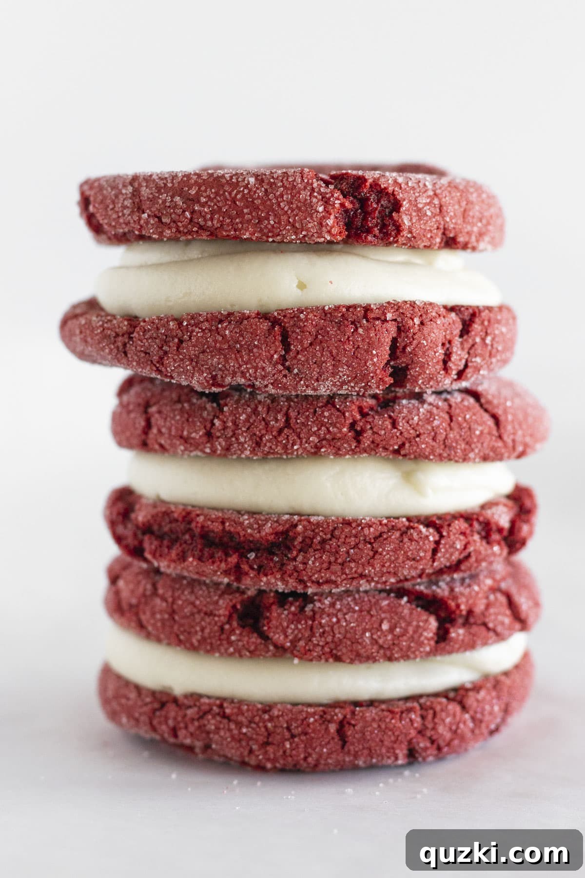 Holiday Cookie Exchange Favorites 9 A stack of luxurious Red Velvet Sandwich Cookies, generously filled with creamy cream cheese frosting, presented elegantly for a delightful treat.