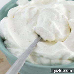 Fresh made whipped cream in a bowl with a spoon for serving.