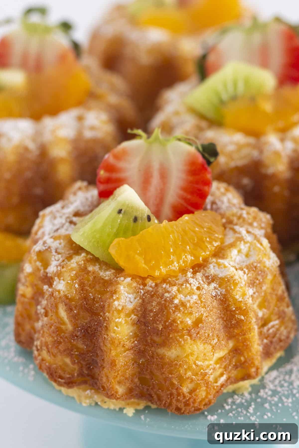 Irresistible Miniature Pound Cakes 7 Mini pound cakes elegantly displayed with fresh fruit on a pristine cake plate.