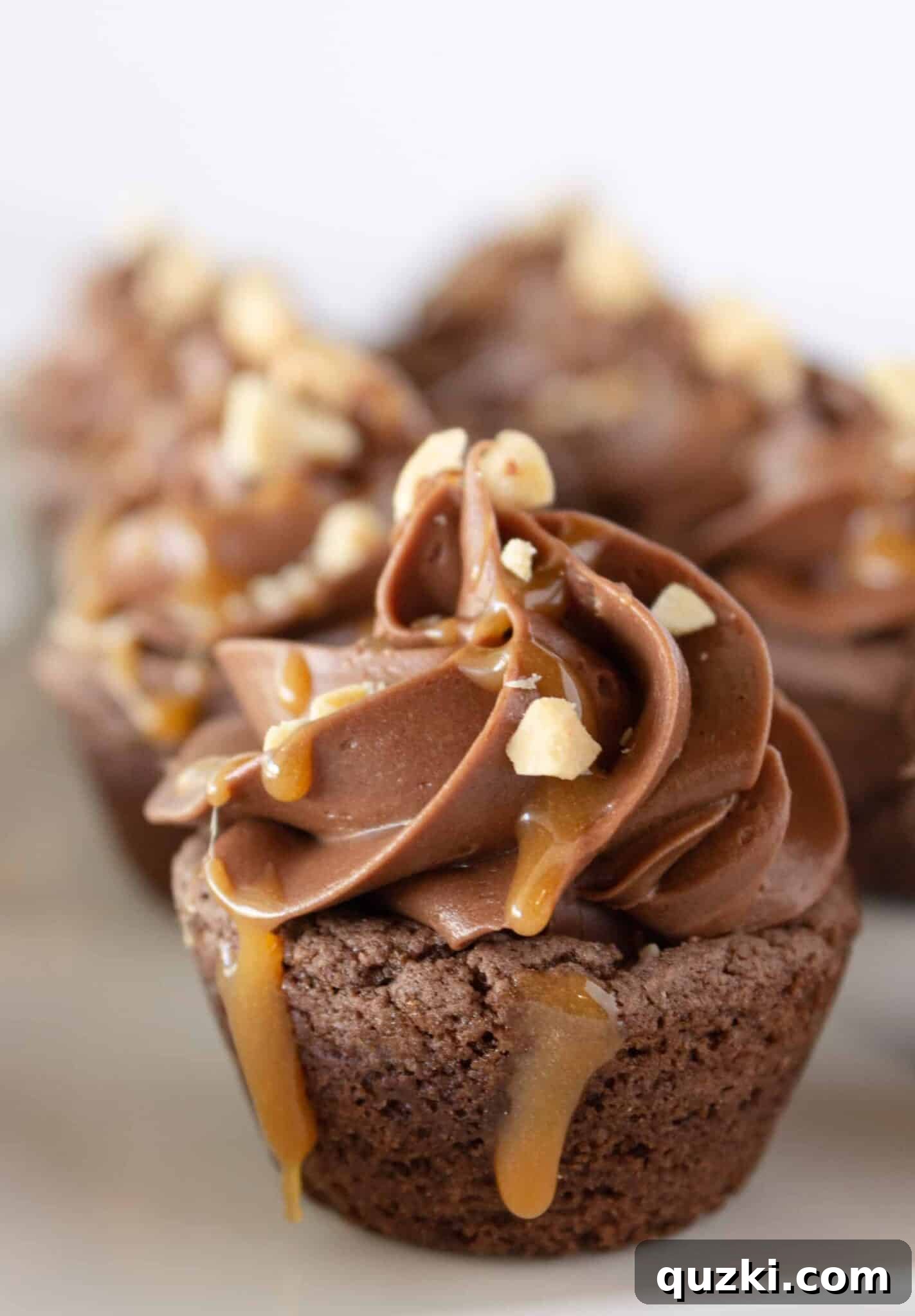 Cake Mix Cookie Magic: Decadent Chocolate Treats 12 Sweet Snickers Cookie Cups, filled with candy bar pieces and drizzled with caramel sauce, for a decadent treat.