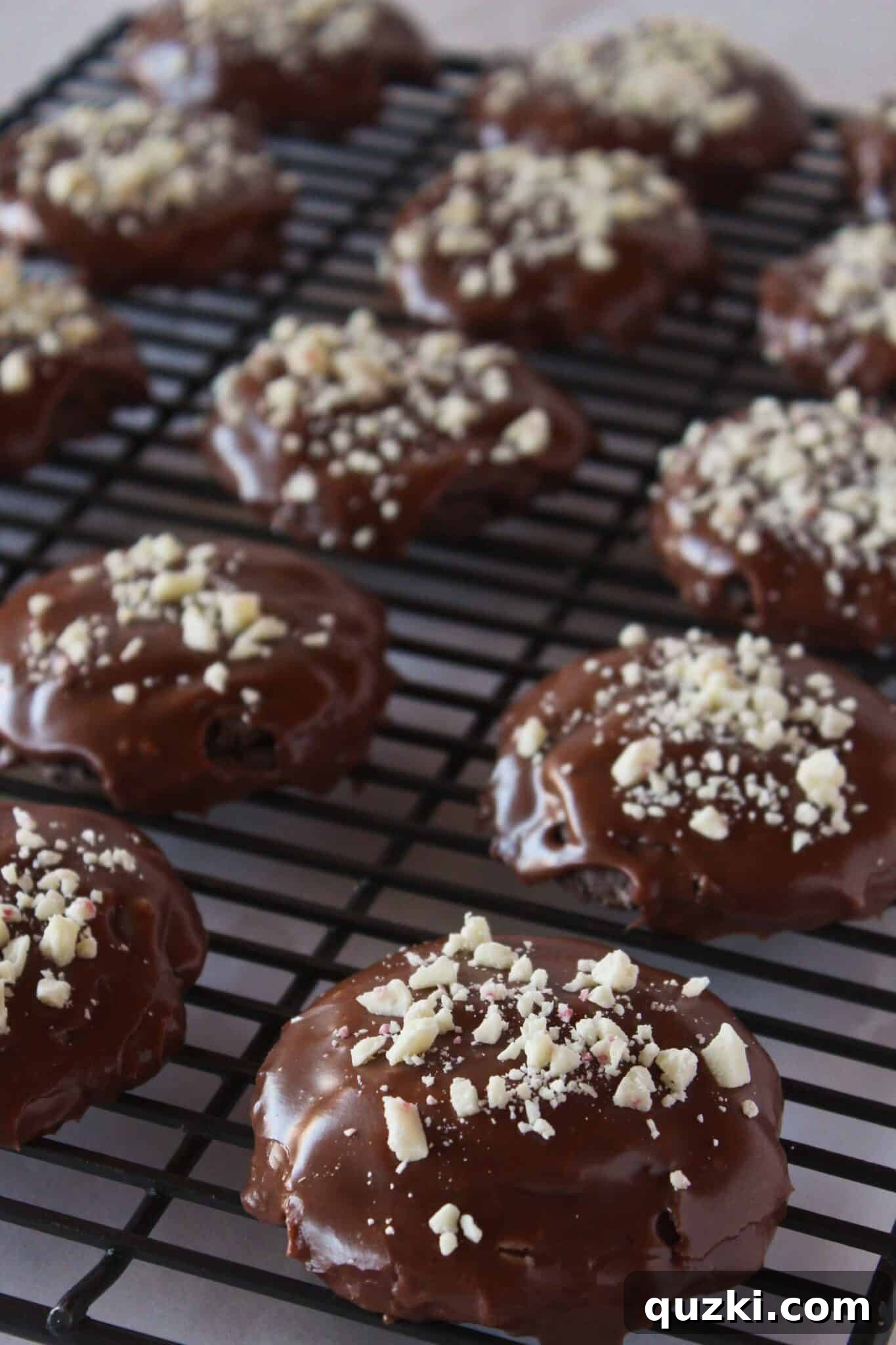 Cake Mix Cookie Magic: Decadent Chocolate Treats 26 Festive Chocolate Peppermint Cookies cooling on a wire rack, topped with crushed candy canes.