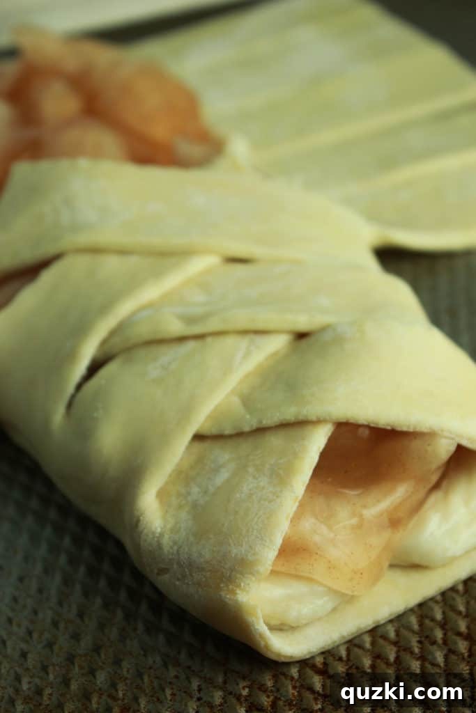 Sweet Apple Cream Cheese Braid 4 Close-up of the initial diagonal folds of puff pastry over the apple and cream cheese filling.