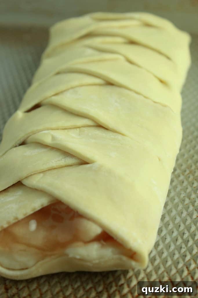 Sweet Apple Cream Cheese Braid 5 Half-braided puff pastry showing the alternating strips covering the apple and cream cheese filling.