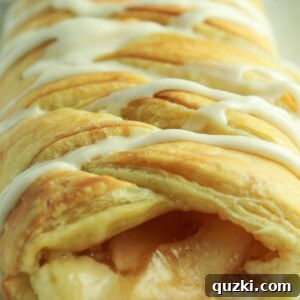 Sweet Apple Cream Cheese Braid 8 A beautifully baked Apple Cream Cheese Braid with vanilla frosting, sliced and ready to serve.