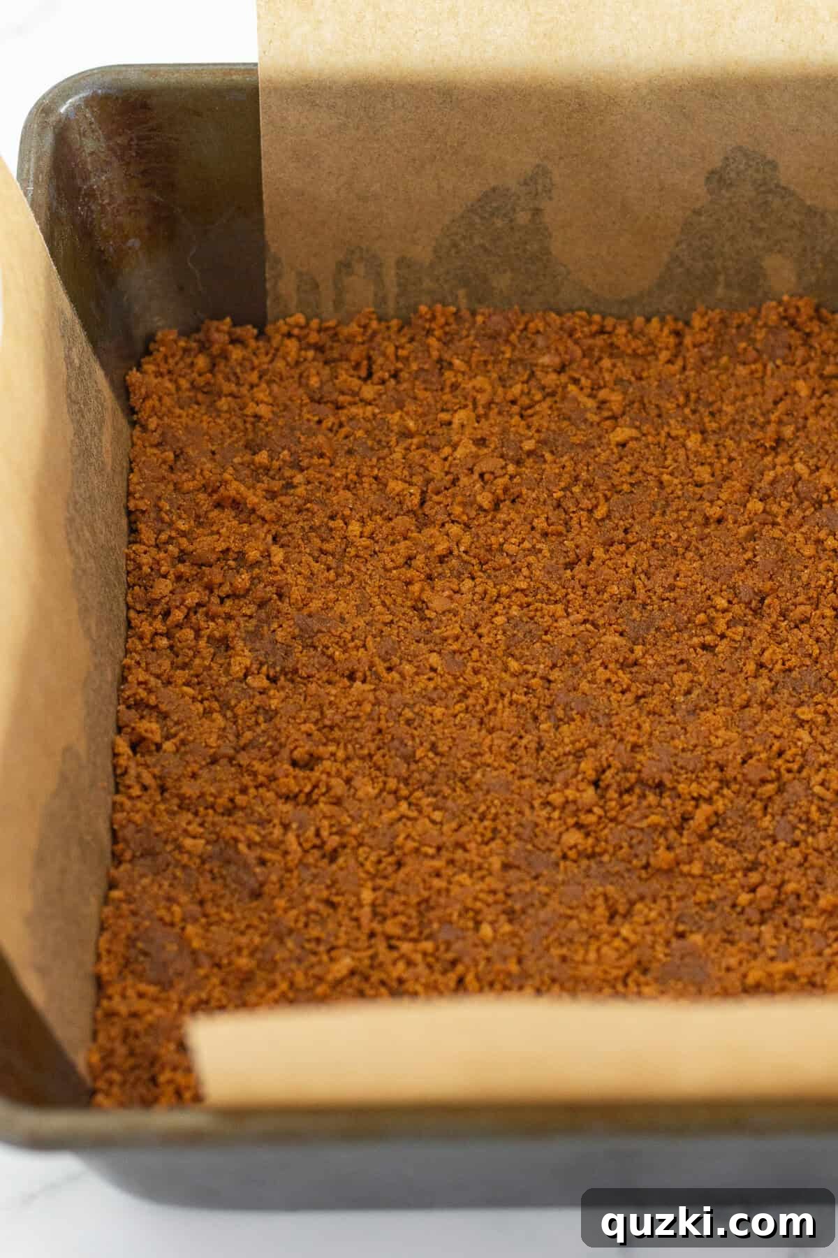 Fudgy Biscoff Cookie Butter Swirl Brownies 5 Pressing the Biscoff cookie crust into a prepared 8x8 baking pan.