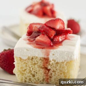 Two slices of vanilla sheet cake frosted with cream cheese frosting and topped with strawberries.
