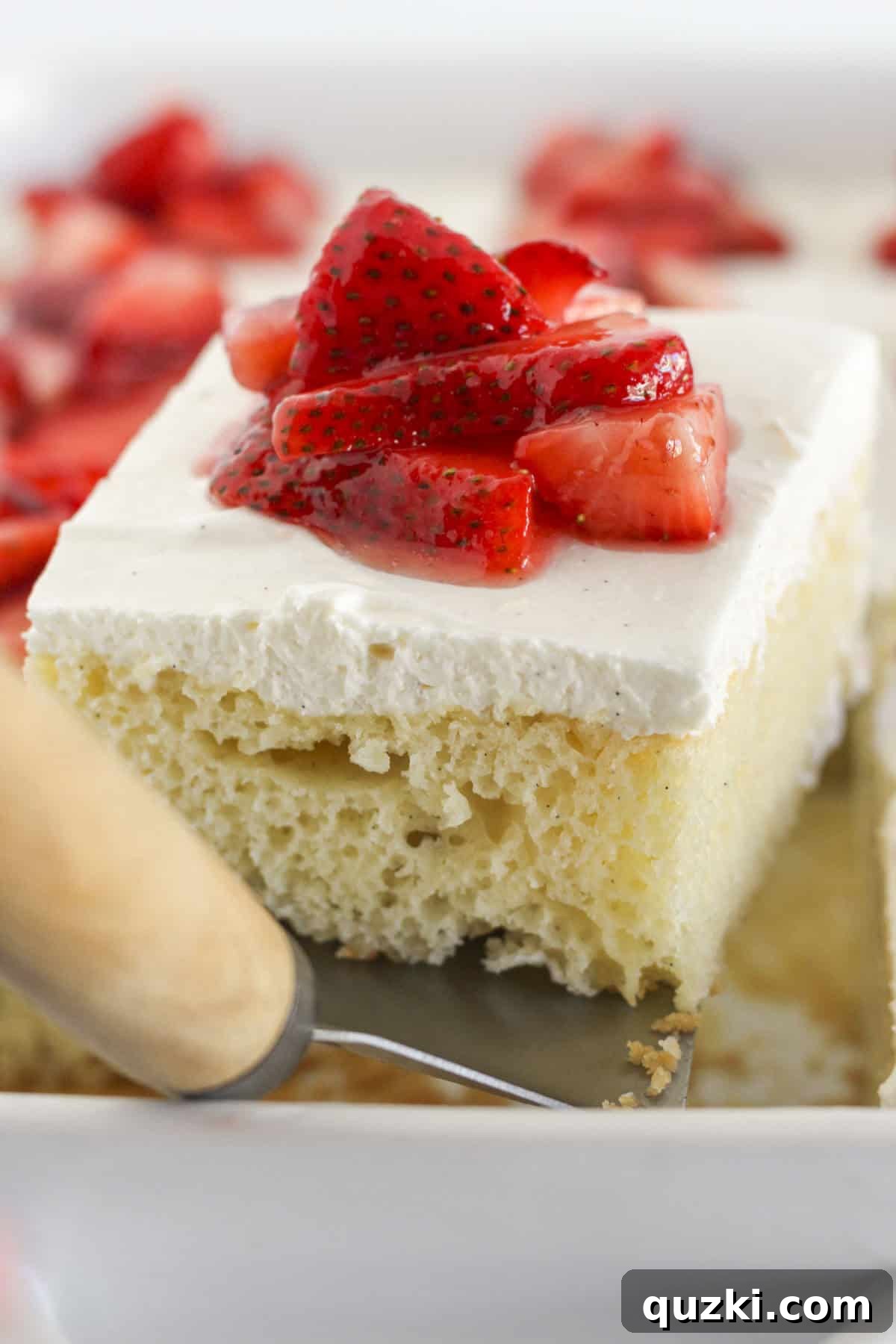 Perfect Vanilla Sheet Cake 10 Removing a perfectly baked slice of vanilla sheet cake from the pan with a spatula.