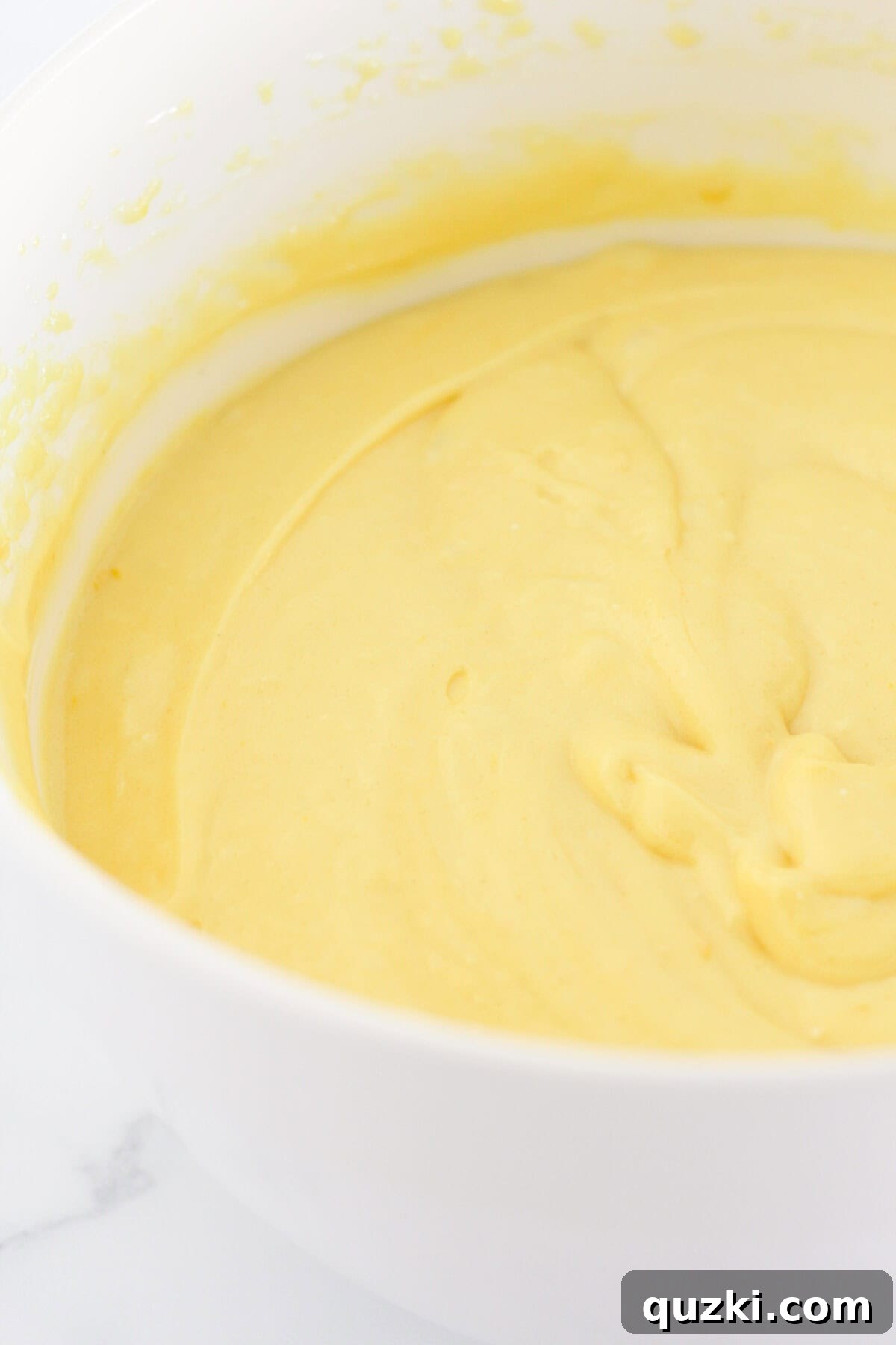 Sunshine Lemon Loaf 4 A bowl filled with the creamy, pale yellow lemon loaf batter, ready for baking.