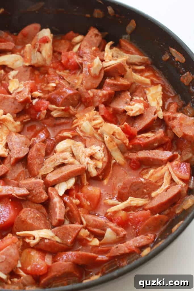 Fast and Flavorful 15-Minute Andouille Sausage Grits 6 Cooked chicken and chicken broth added to the flavorful Andouille sausage and tomato mixture, simmering gently on the stovetop to develop rich flavors.