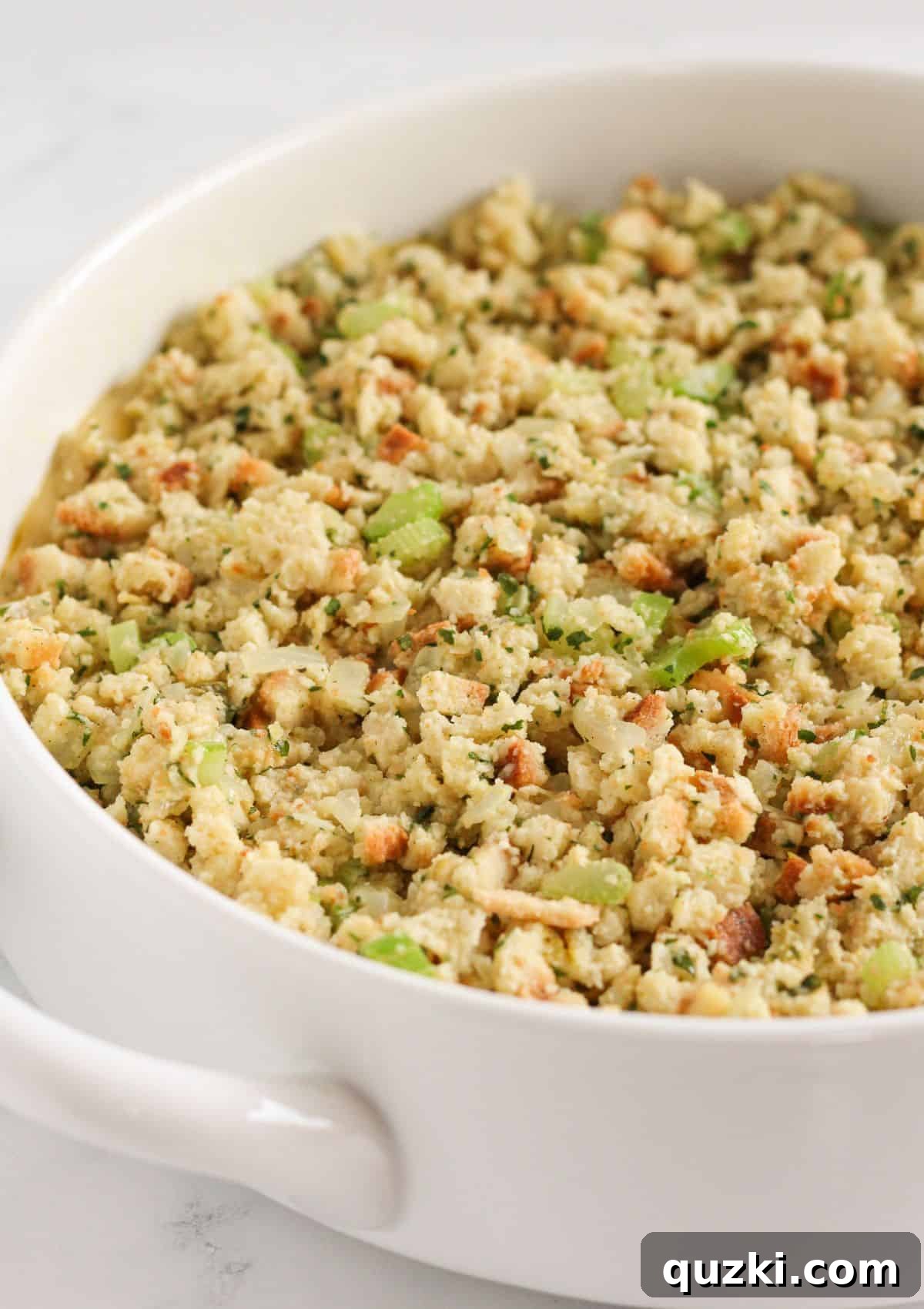 The chicken and creamy sauce mixture spread evenly in the baking dish, topped with the prepared stuffing mixture.