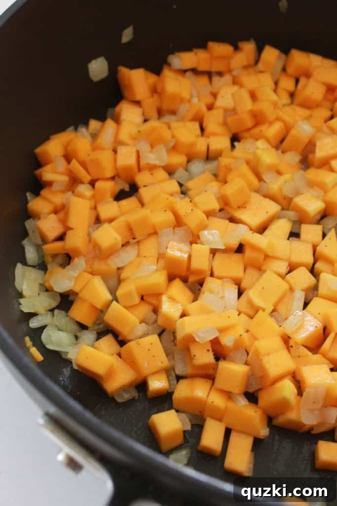 Golden Butternut Parmesan Pasta 3 Diced onions, garlic, and butternut squash simmering in a pan, forming the aromatic base for the creamy pasta sauce.