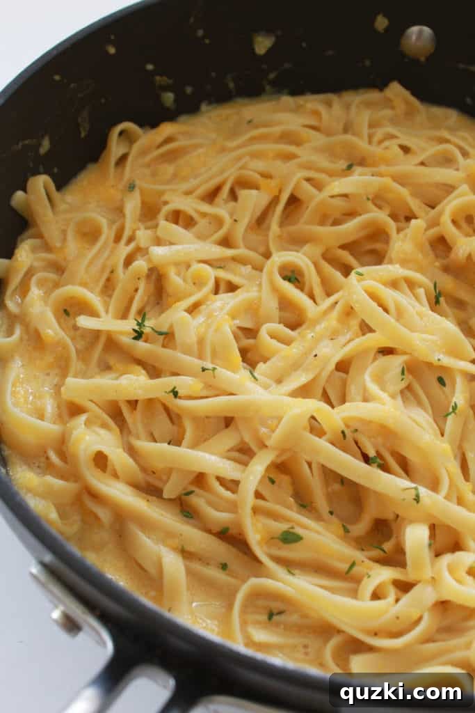 Golden Butternut Parmesan Pasta 8 Butternut squash and Parmesan pasta tossed together in a pan, vibrant and creamy, ready for serving.