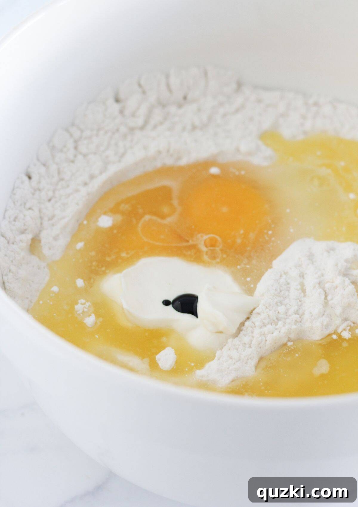 Adding the wet ingredients to the dry cake mix and flour.