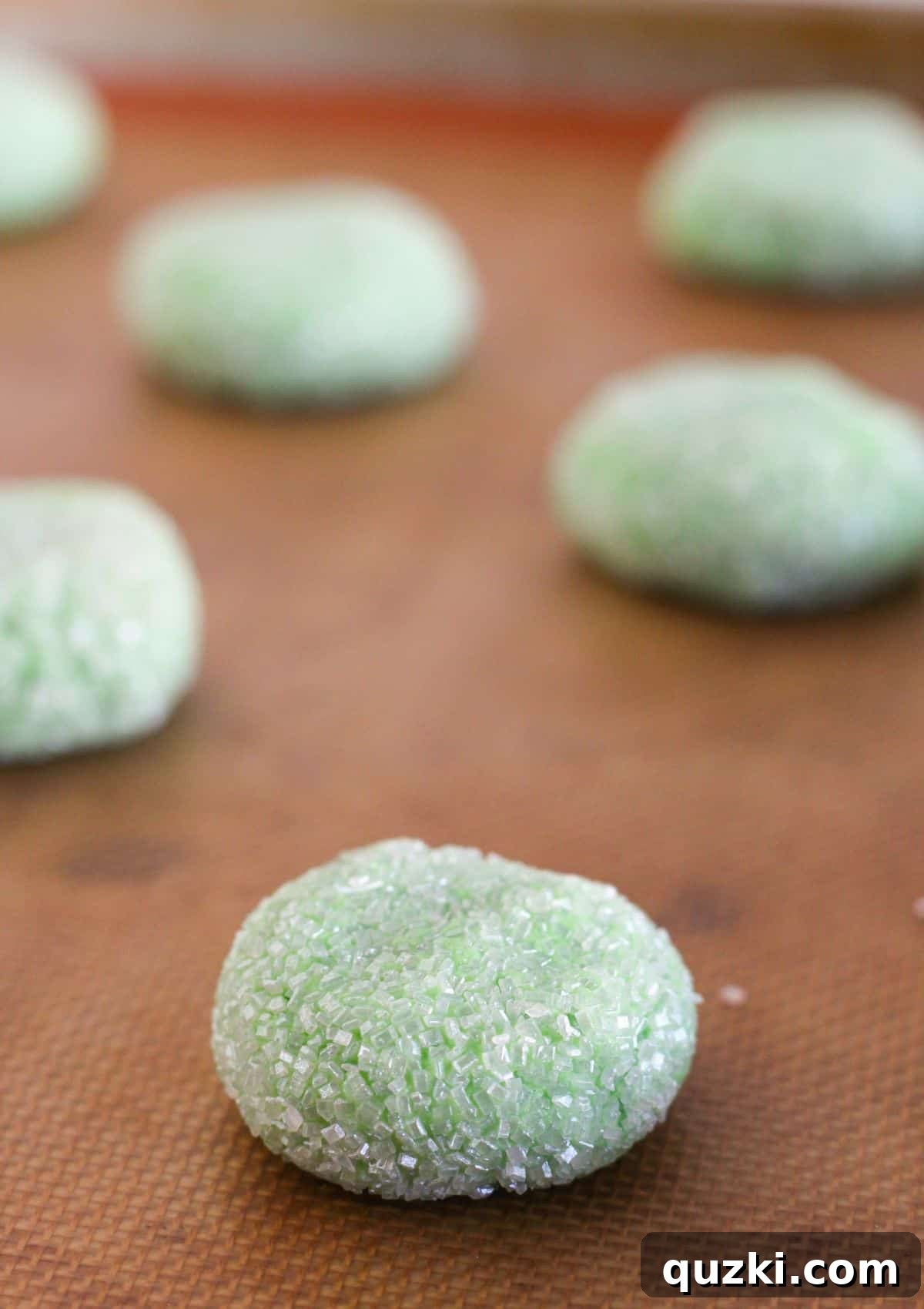 Adding the sugar-coated, disc-shaped cookie dough onto a baking sheet.