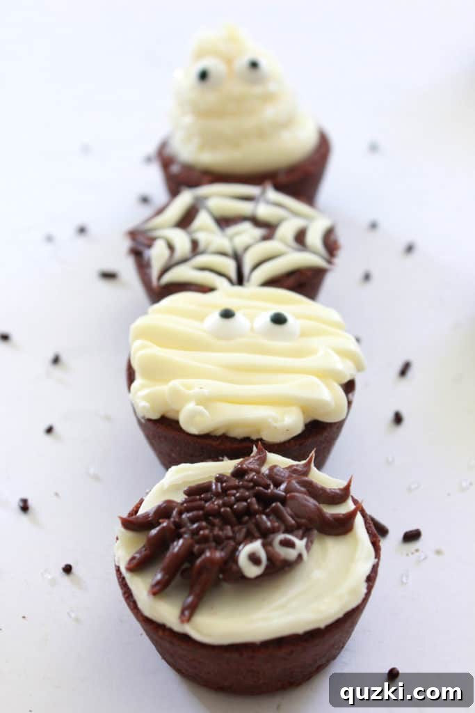 Ghoulishly Good Halloween Brownie Bites 15 An assortment of all four Halloween Brownie Bite designs – ghosts, spider webs, mummies, and spiders – beautifully arranged on a tray, ready for a party.