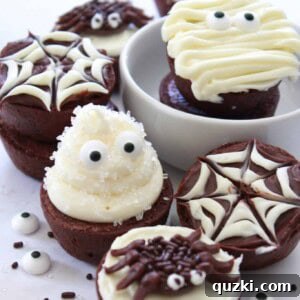 A close-up image of an assortment of creatively decorated Halloween Brownie Bites, including ghosts, mummies, spiders, and spider webs, presented invitingly.