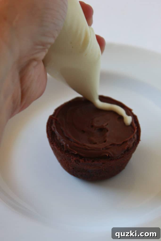 Ghoulishly Good Halloween Brownie Bites 5 A Spider Web Halloween Brownie Bite showing a base layer of chocolate frosting with a vanilla frosting spiral piped on top.