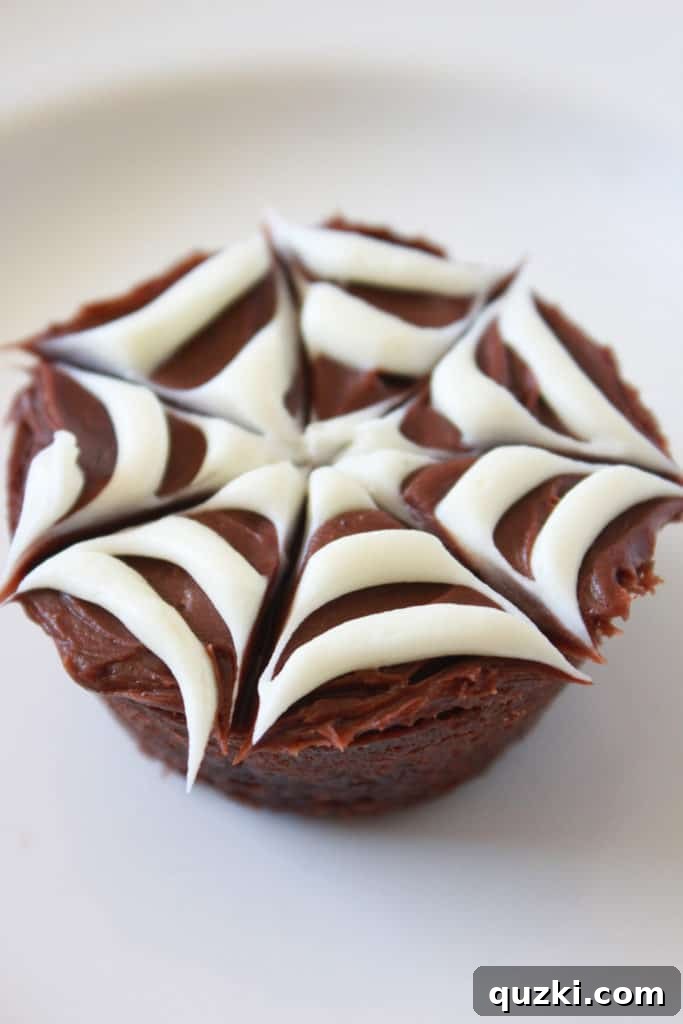 Ghoulishly Good Halloween Brownie Bites 7 A completed Spider Web Halloween Brownie Bite with an M&M in the center representing a spider, ready for serving.