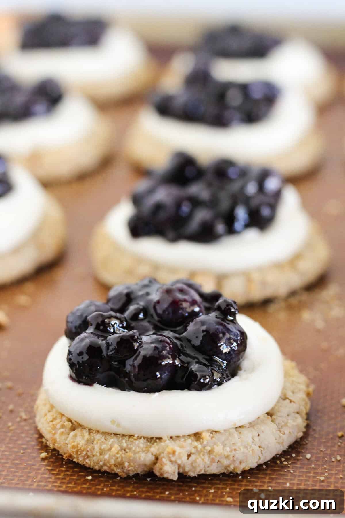 Vanilla Cake Mix: A Perfect White Cake Substitute? 3 Blueberry cheesecake cookies with frosting and topping, ready to be enjoyed.