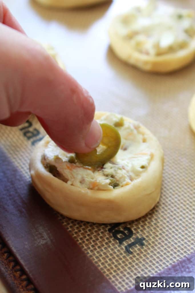 Spicy Jalapeño Crescent Poppers 7 Topping each Jalapeno Popper Crescent Bite with an optional slice of pickled jalapeno before baking for extra flavor and garnish.