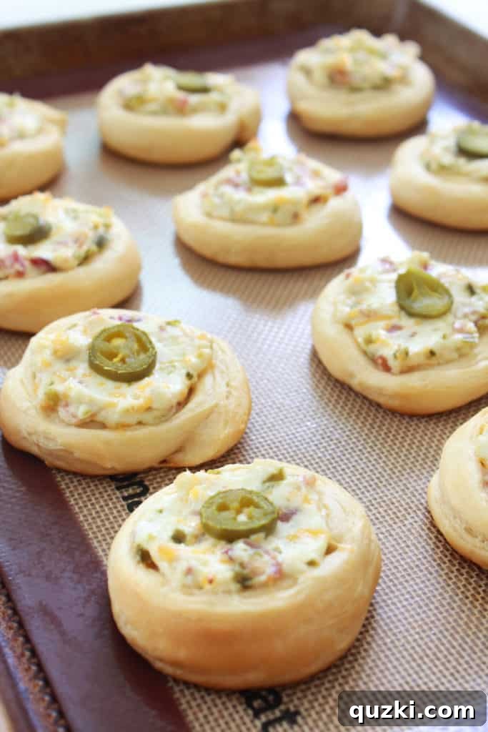 Spicy Jalapeño Crescent Poppers 8 Freshly baked Jalapeno Popper Crescent Bites, golden brown and ready to serve, a perfect party food.