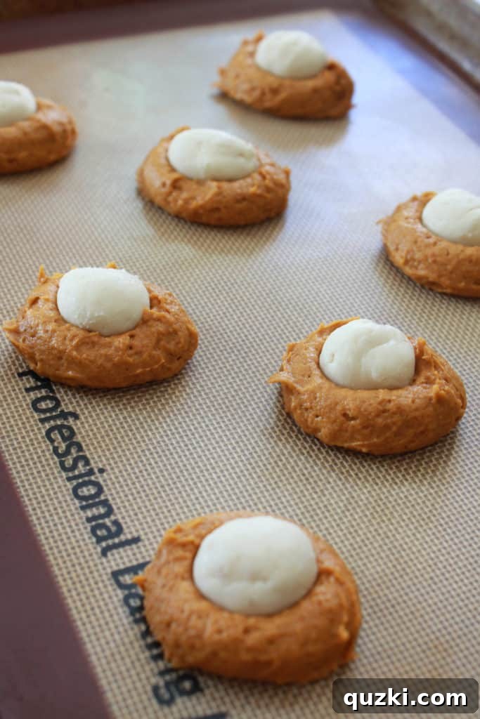 Pumpkin Swirl Cookies 5 Scooping pumpkin cookie dough onto a baking sheet and placing a frozen cream cheese ball in the center.