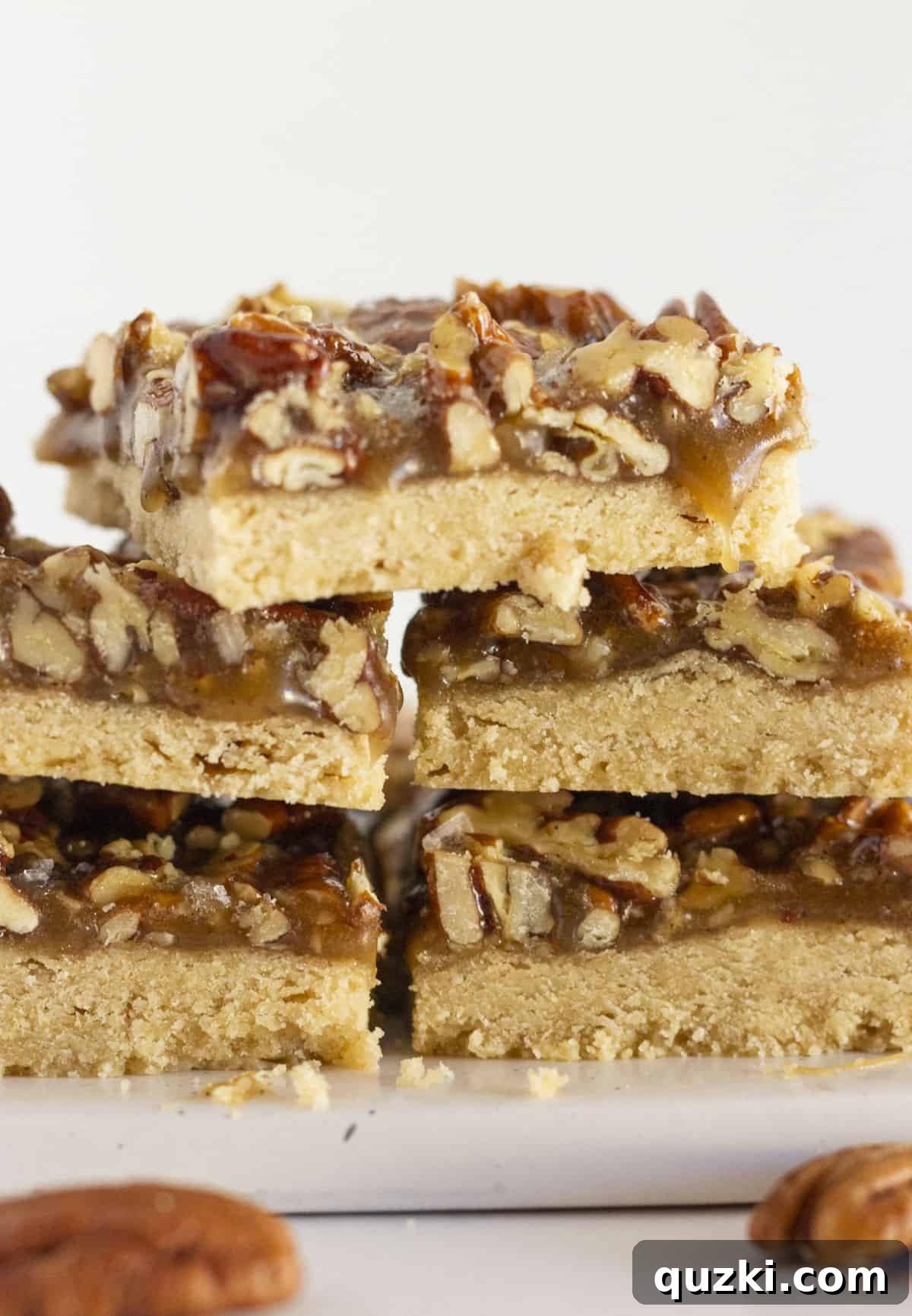 Buttery Pecan Shortbread Bars 7 Baked pecan shortbread bars neatly arranged on a white plate, ready for serving.