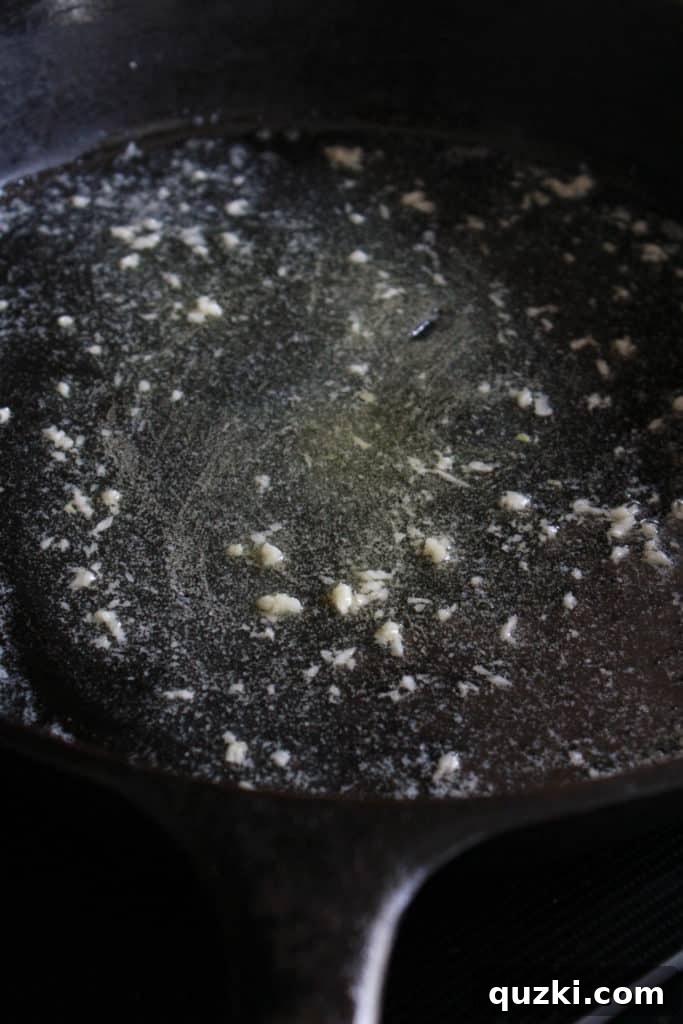Creamy Sweet and Yukon Gold Potato Skillet Gratin 4 Stirring minced garlic into melted butter in a warm cast iron skillet